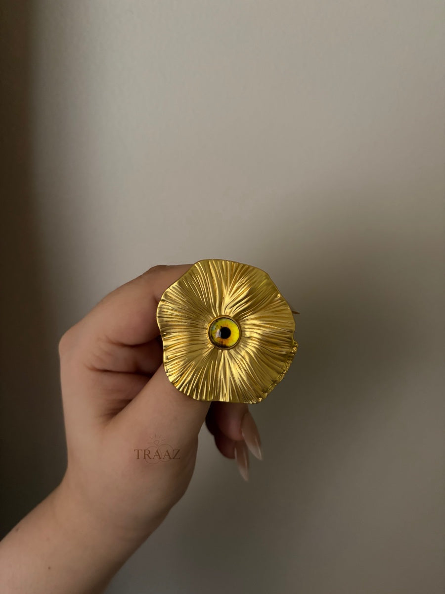 yellow eye gold brooch